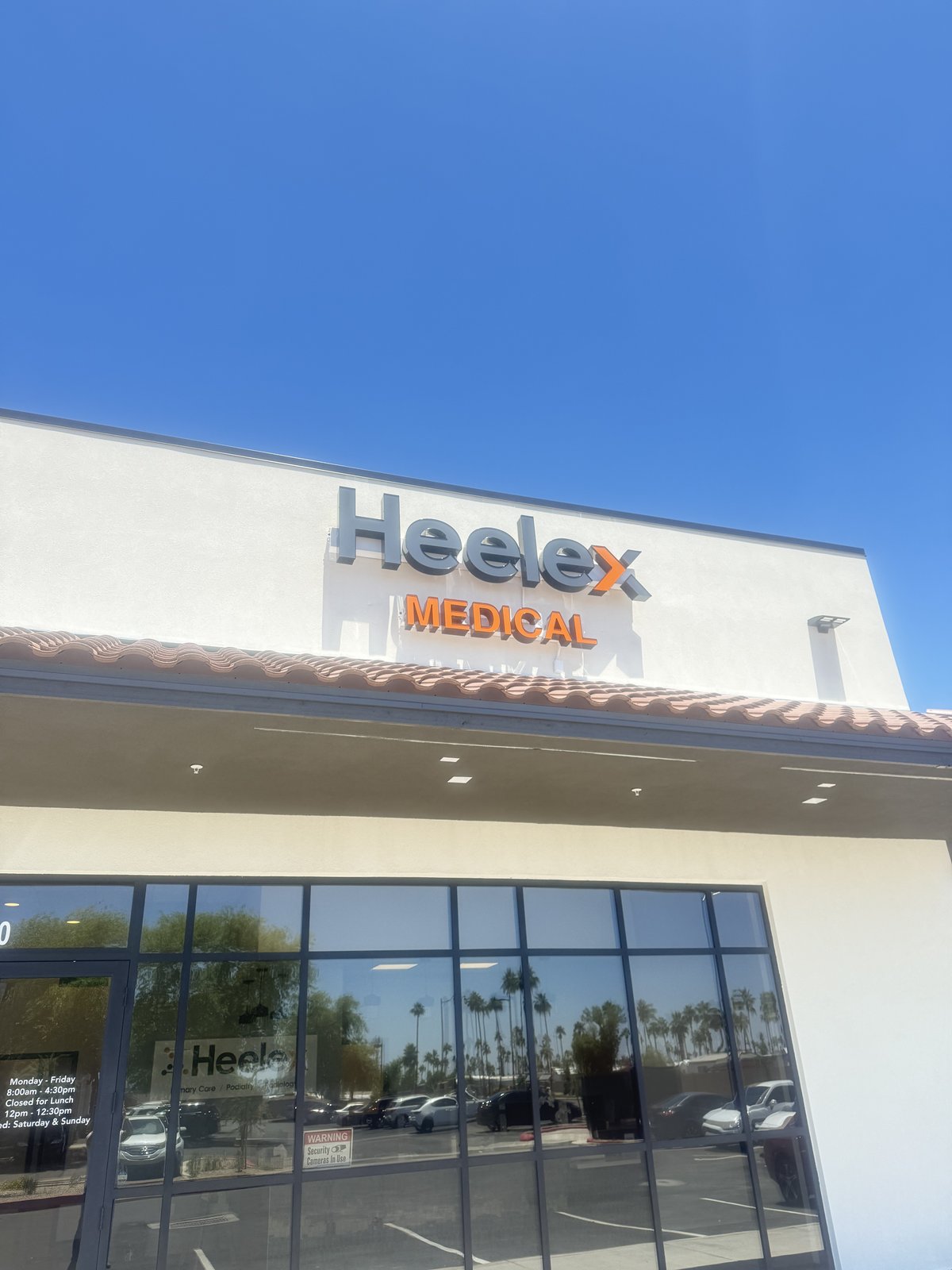 Exterior of the Heelex Medical clinic in Surprise, Arizona, showing the orange and gray Heelex logo and main entrance.