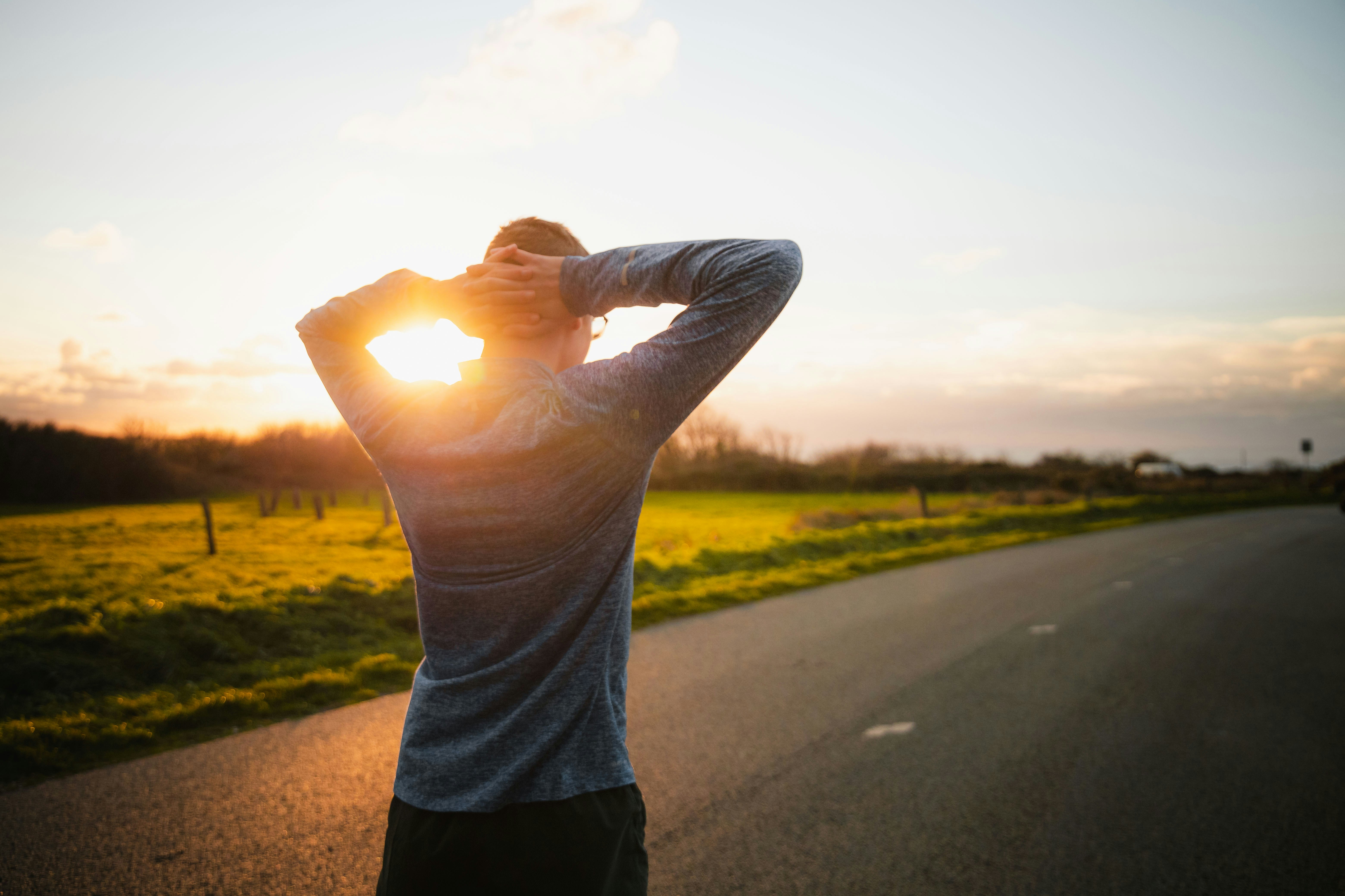 A person at rest at sunset, hands behind the head.
